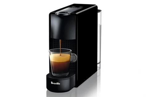 Black Breville coffee machine dispensing a shot of espresso into a glass.